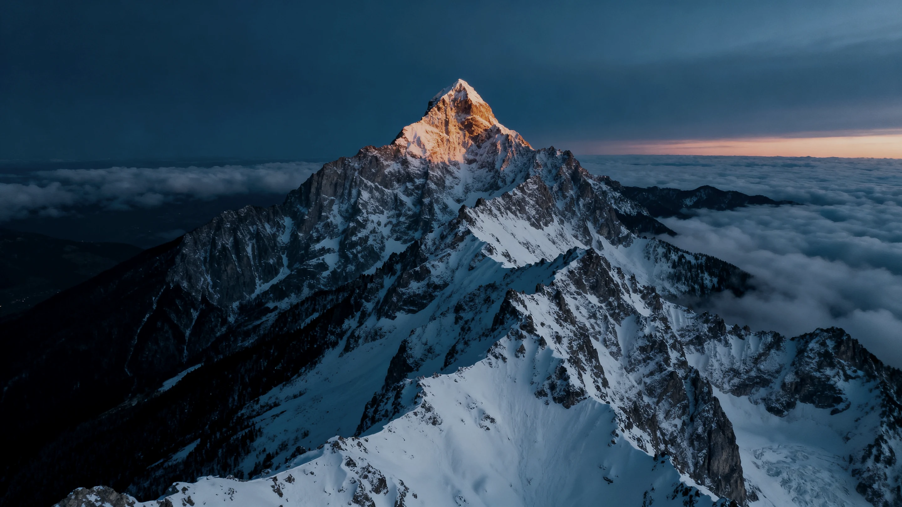 Alpine summit at first light above a sea of cloud