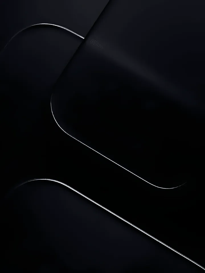 Near-black panels layered at an angle, each rounded edge traced by a thin bright seam where it catches the light